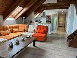 ein Wohnzimmer mit einem orangenen Sofa und einem Tisch in der Unterkunft BPIRINEOS-Aigualluts in Benasque