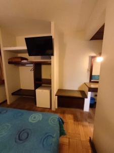 a room with a bedroom with a bed and a tv at Hotel Elo Curitiba in Curitiba