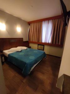 1 dormitorio con cama y ventana grande en Hotel Elo Curitiba, en Curitiba