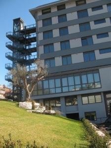 a tall building with a tree in front of it at Park Hotel Sporting in Teramo