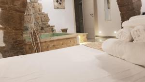 een kamer met een bad op de achtergrond en witte handdoeken bij Janara - Arco di Traiano in Benevento