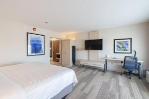 Pokój hotelowy z łóżkiem, biurkiem i telewizorem w obiekcie Holiday Inn Express & Suites - Marion, an IHG Hotel w mieście Marion