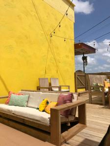 a couch with colorful pillows on a patio at Yellow Belly Backpackers in San Ignacio