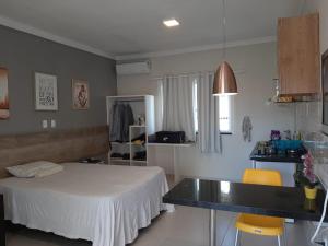 een slaapkamer met een bed, een tafel en stoelen bij Atalaia mar in Aracaju