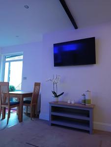 a living room with a table and a tv on the wall at Catherine Street Apartments in Salisbury