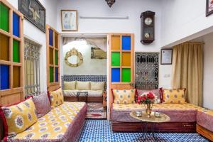 ein Wohnzimmer mit einem Sofa und einem Tisch in der Unterkunft Dar Fatimazahra in Fès
