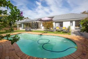 a swimming pool in the backyard of a house at Casa iLanga guesthouse in Somerset West