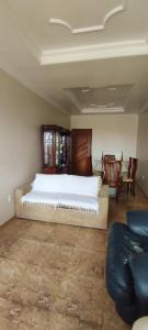 een slaapkamer met een bed en een bank en stoelen bij Lindo Apartamento Praia do Forte in Cabo Frio