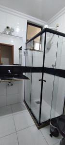 een badkamer met een glazen kast en een spiegel bij Lindo Apartamento Praia do Forte in Cabo Frio