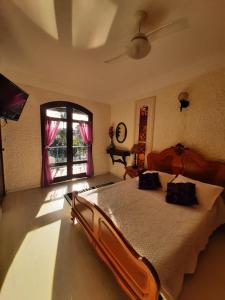 een slaapkamer met een groot bed en een raam bij Pousada Chez Moi in Cabo Frio