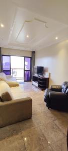 a living room with two beds and a television at Lindo Apartamento Praia do Forte in Cabo Frio