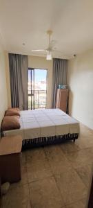 een slaapkamer met een groot bed en een raam bij Lindo Apartamento Praia do Forte in Cabo Frio