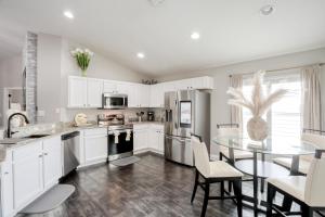 a kitchen with white cabinets and a glass table at Remington View Retreat in Kissimmee