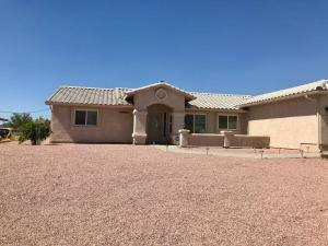 a house with a gravel driveway in front of it at PRIVATE VIEW ON THE LAKE SIDE OF 95! Sleeps 16 in Lake Havasu City