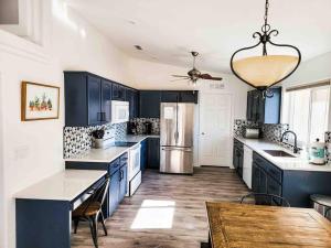 a large kitchen with blue cabinets and a table at PRIVATE VIEW ON THE LAKE SIDE OF 95! Sleeps 16 in Lake Havasu City
