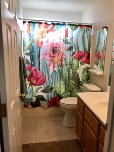 a bathroom with a cactus shower curtain with a toilet at PRIVATE VIEW ON THE LAKE SIDE OF 95! Sleeps 16 in Lake Havasu City