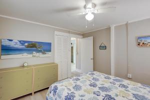 - une chambre avec un lit et un ventilateur de plafond dans l'établissement SeaEscape, à Folly Beach