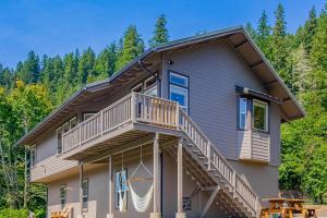 a large house with a deck and stairs at Siuslaw River House in Mapleton
