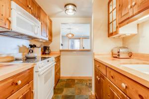 a kitchen with wooden cabinets and white appliances at Tensleep B9 in Teton Village