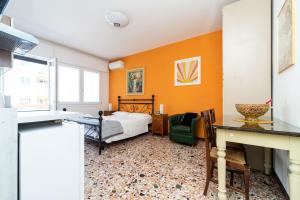 メストレにあるMonti Guesthouseのオレンジ色の壁のベッドルーム1室、ベッド1台(テーブル付)