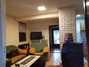 a living room with a couch and a tv at Relax house in Visoko