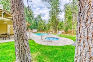 un patio trasero con piscina y árboles en Slide Creek Retreat en Bass Lake