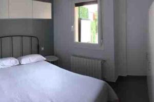 1 dormitorio con cama blanca y ventana en Etxe Txiki en Kortezubi (Urdaibai), 
