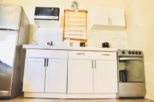 a kitchen with white cabinets and a sink and a refrigerator at Northside Hideaway in Nazareth
