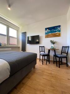 1 dormitorio con 1 cama, mesa y sillas en La Playa Apartments en Hel