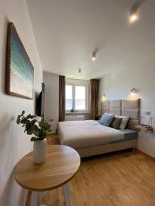 Un dormitorio con una cama y una mesa. en La Playa Apartments en Hel