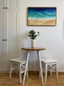 una mesa con dos sillas y un jarrón con una planta en La Playa Apartments en Hel