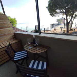 una mesa y 2 sillas con copas de vino en el balcón en The View - Sunset & Relax - Suite - Appartamenti Vista Lago en Passignano sul Trasimeno