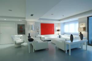 a living room with white furniture and a red wall at Park Hotel Sporting in Teramo