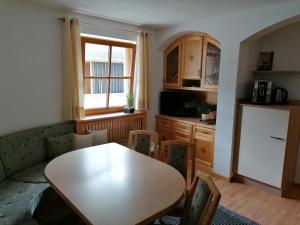 ein Wohnzimmer mit einem Tisch und einer Küche in der Unterkunft Apart Edi in Kappl