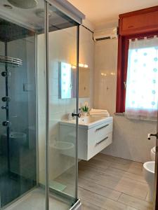 een badkamer met een glazen douche en een wastafel bij DomoMea - Angela in Quartu SantʼElena