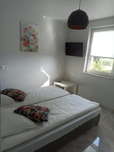 a bedroom with a bed with two pillows on it at Agroturystyka u Basi in Wola Kalinowska
