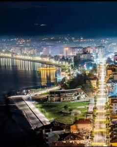 a view of a city at night with the water at Klent Studio Apartment in Pogradec