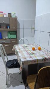 uma cozinha com uma mesa com duas laranjas em Minha casa fora de casa em Jandira