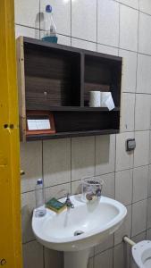 uma casa de banho com um lavatório branco e um armário em Minha casa fora de casa em Jandira
