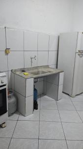 a kitchen with a sink and a refrigerator at Minha casa fora de casa in Jandira