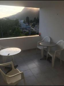 a room with two tables and chairs and a window at Mica apartmani in Sutomore