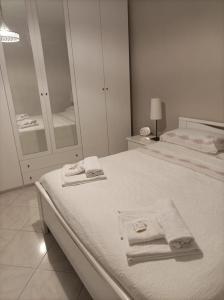 una camera da letto bianca con un letto e asciugamani di Casa DoriDa' a Lanciano