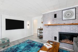 a living room with a brick fireplace and a tv at River House on Berwick Trail in Nashville