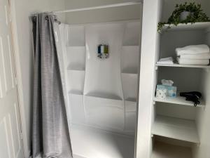 een kast met witte planken en een douchegordijn bij The St Maries Inn in Saint Maries +33 foto's