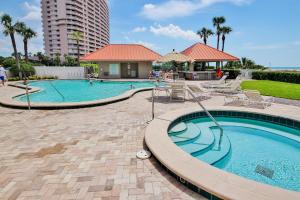 a swimming pool in a resort with palm trees and a building at Lighthouse Towers 1002 in Clearwater Beach