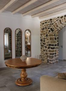 uma sala de estar com uma mesa e uma parede de pedra em Aeonian Villa Ermioni em Ermioni