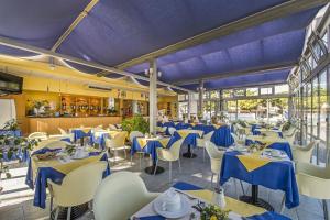 un ristorante con tavoli e sedie blu e bianchi di Hotel Minerva a Lignano Sabbiadoro