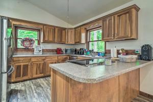a kitchen with wooden cabinets and a granite counter top at Home on Douglas Lake - Fish and Kayak! in Dandridge