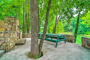 a green picnic table sitting next to a tree at Home on Douglas Lake - Fish and Kayak! in Dandridge