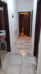 a hallway with a door and a tile floor at Cool Bayader apartment in Amman